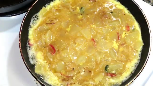 Thick Spanish-style potato omelette with golden potatoes, onions, and fresh coriander served on a plate