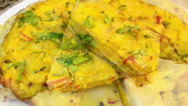 Thick homemade Spanish potato omelette cut into wedges with golden potatoes, onions, and fresh coriander