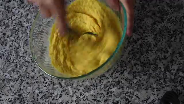 Thick moong dal batter being vigorously whisked until light and airy