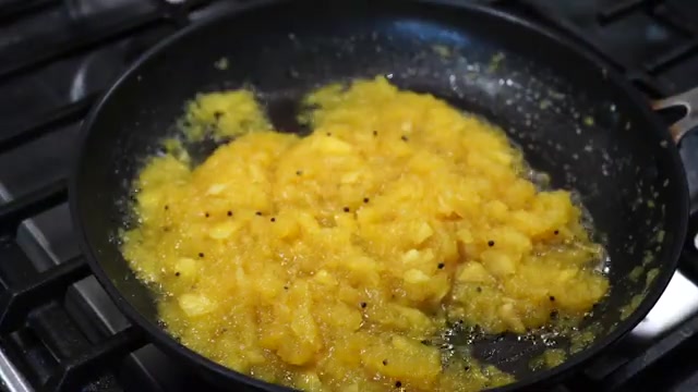 Thick pineapple chutney being stirred and adjusted with a little water
