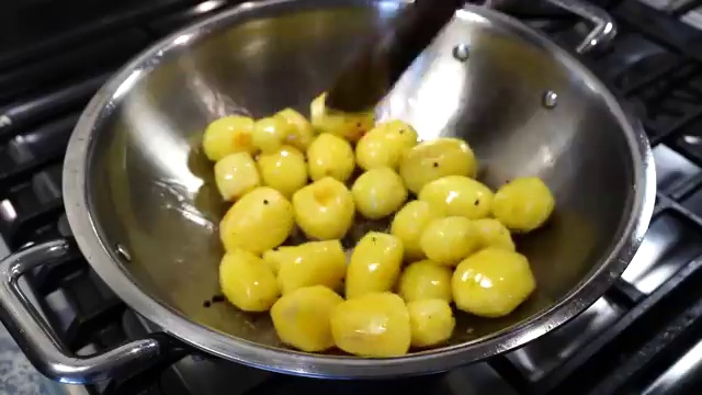Thinly sliced onions added to the skillet with the partially fried baby potatoes