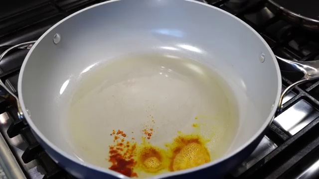 Seasoned extra-firm tofu cubes arranged in a single layer in a non-stick skillet