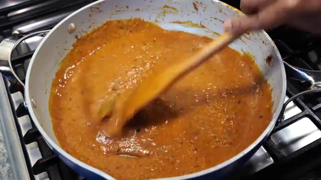 Tofu pieces simmering gently in the rich red-orange masala gravy to absorb spices