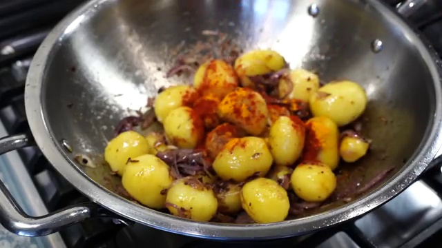Fresh chopped tomatoes cooking down and softening into a rich masala with the potatoes