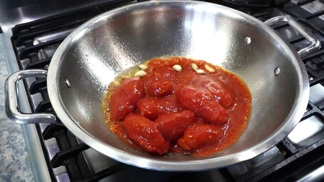 Tomato, ginger, and garlic sauce simmering and reducing into a thick rich base