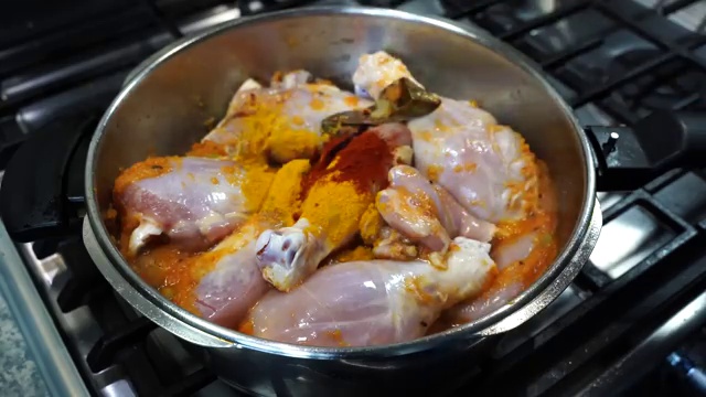 Golden turmeric powder, Kashmiri chili powder, ground black pepper, and salt sprinkled over chicken
