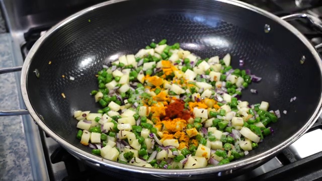 Turmeric, Kashmiri chili powder, ground cumin, and salt added to the potato and bean mixture