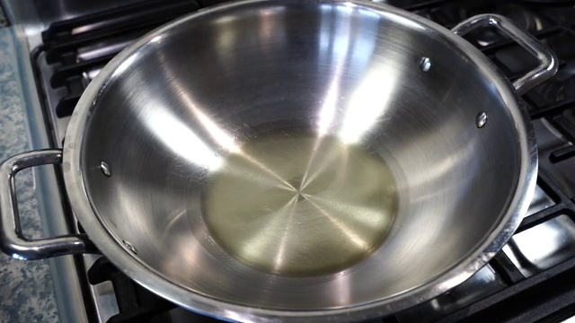 Turmeric powder added to hot oil in a pan before frying the potatoes