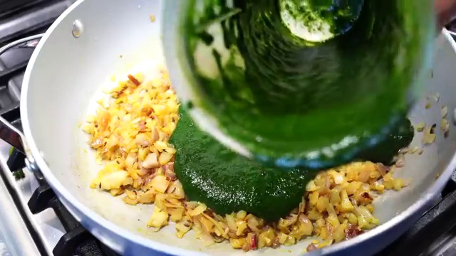 A pinch of turmeric powder added to softened pale onions in the pan