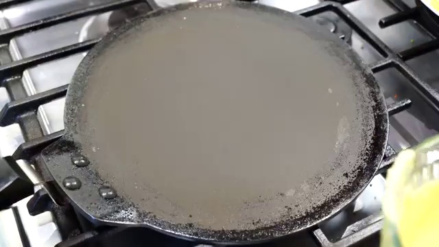 Open-faced vegetable-topped moong dal chilla cooking flipped on the second side to lightly toast the veggies