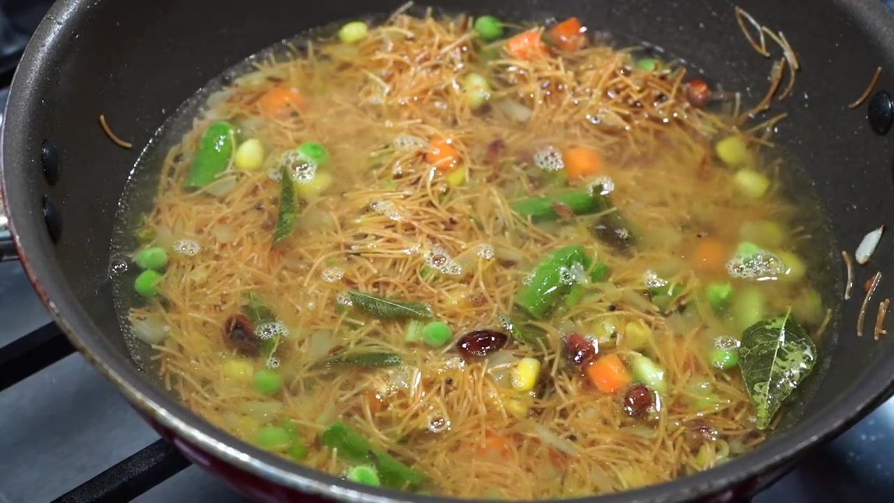Vermicelli upma simmering under a lid as the vermicelli absorbs the hot water