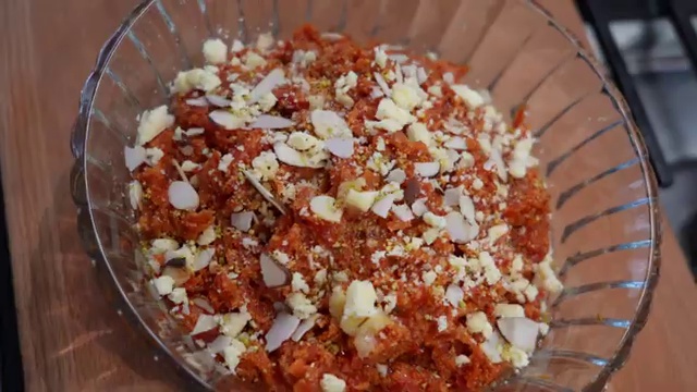 Warm Indian carrot halwa served with toasted almonds in a traditional dessert bowl