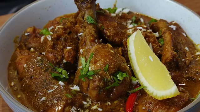 Whole Xacuti spices including cumin, coriander, fennel, cinnamon, and cloves added to warm oil