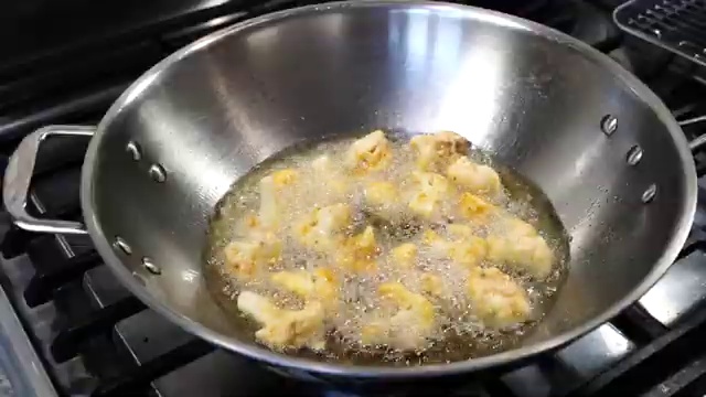 Wok with one tablespoon of reserved oil remaining after frying the cauliflower